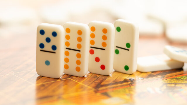 Domino tiles lined up on game board representing process, strategy and chain reaction concept.