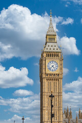 Obraz premium Big Ben clock tower against a blue sky with fluffy white clouds