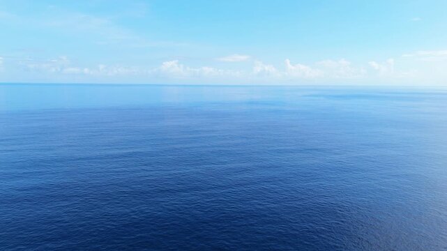 Drone aerial shot of glassy ocean surface with calm tropical conditions and dramatic cloudy sky