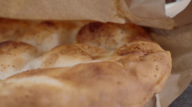 Fresh bread being pulled from paper bag in market