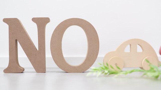 車利用を否定するNOサインと木製おもちゃ。