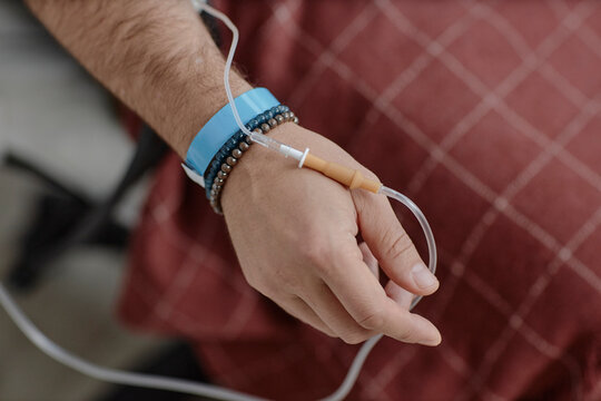 Hand with IV therapy and catheter during infusion in hospital