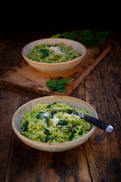 Orzo with spinach and Swiss chard pesto served in rustic bowls