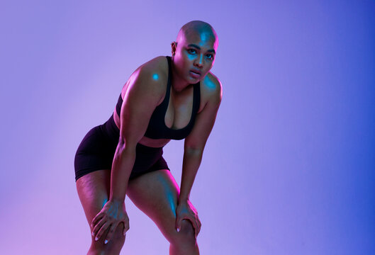 Bald athlete in sportswear posing confidently in a studio