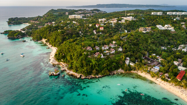 aerial perspective of Boracay Island's coastline in the Philippines. Showcasing the vibrant coral reefs, clear blue ocean, and pristine white sand beaches