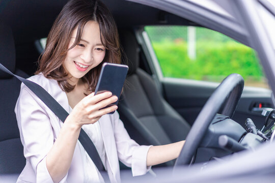 スマホを使いながら車を運転する女性