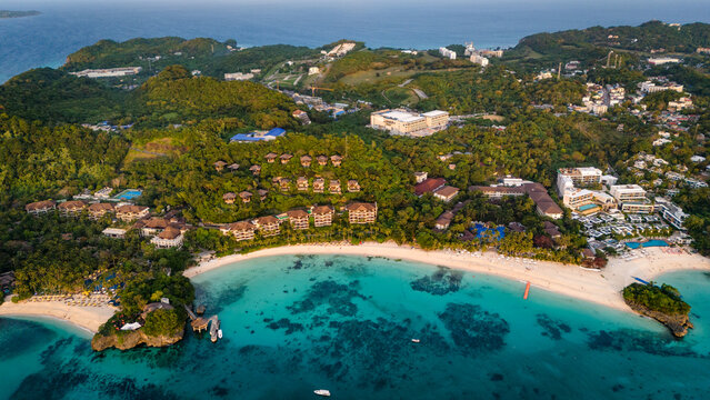 drone above Boracay at White Beach, vibrant turquoise ocean and white sandy shoreline lined with palm trees and resorts, Philippines travel holiday