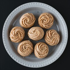 Fototapeta premium Round butter cookies arranged on white plate top view