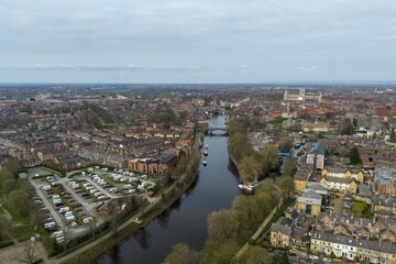 Obraz premium Aerial view photo of the city of York in the UK with River Ouse terraced housing caravan park and York Minster visible in the distance captured from above in early spring time