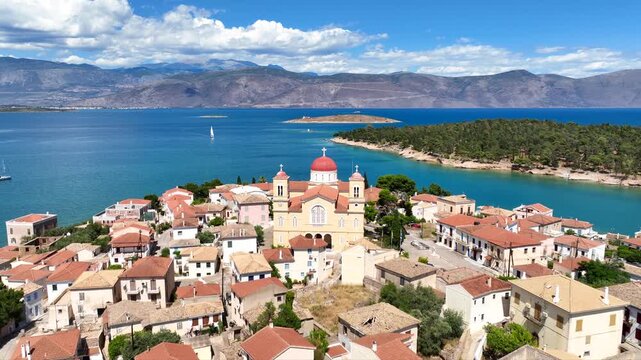 Aerial drone cinematic video from picturesque and traditional historic village of Galaxidi featuring landmark church of Agios Nikolaos, Fokida, Greece