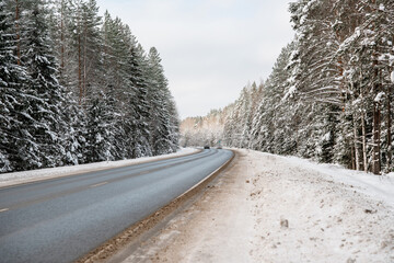 Obraz premium Snow-covered highway in the forest in winter