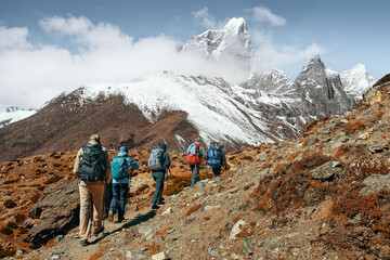 Fototapeta premium Group of tourists with backpacks walking mountain trail during hike of Trekking on Trail to Everest Base Campduring, Nepal.