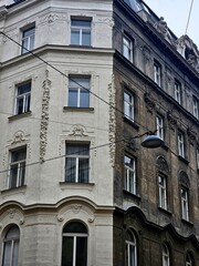 Fototapeta premium Old architecture buildings in Vienna, Austria. View of the corner of the building and the hanging lantern on the wires. The junction of the building's different colors is white and black.