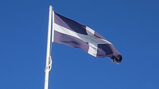 Cornish Flag on Pole Against Blue Sky in Cornwall England Looking Up