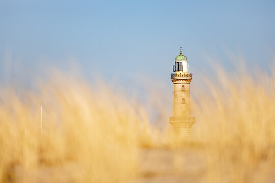 Lighthouse in Warnemuende, Germany behing the blurred marram grass, on sand dunes.