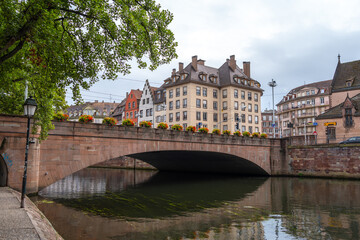 Obraz premium Stone bridge with flowers crossing the Ill river Strasbourg, France