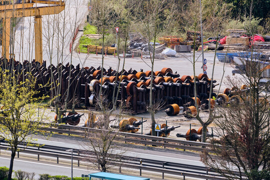 Olaberria, Spain - 09 March 2026: Aerial view of a steel mill's yard, where rows of heavy, rust-tinged machinery rest under the watchful gaze of a towering yellow crane.