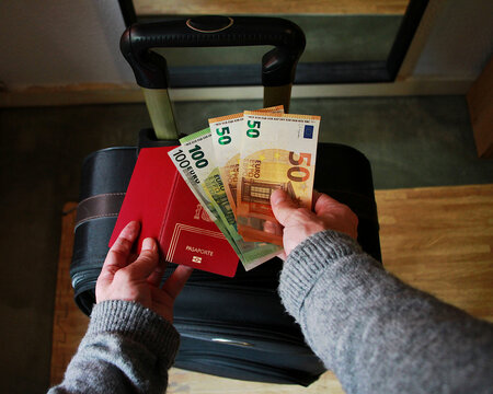 Dinero en billetes de euro y pago por pasaporte en viaje con maleta y visado a extranjero de turismo