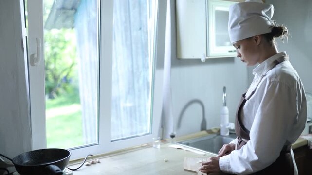A female chef cooks in the kitchen during the day