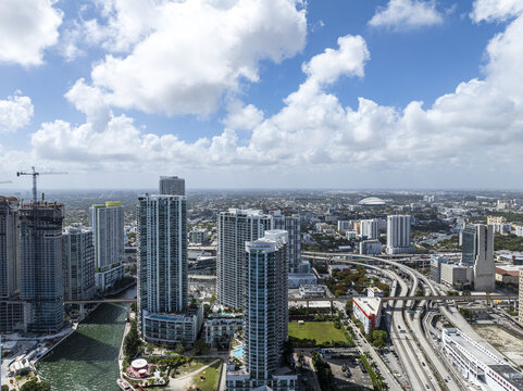 Aerial view of glittering skyscrapers reflecting the azure sky, interwoven with ribbons of highways and the winding river, Brickell, Miami, Florida, United States.