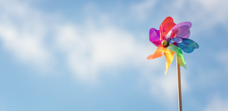 Summer or wind power renewable energy background, windmill or pinwheel against blue sky