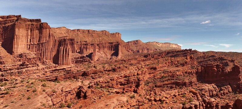 Aerial view of the sun-baked, red rock formations and canyons create a dramatic, textured landscape under a clear, blue sky, Moab, Utah, United States.