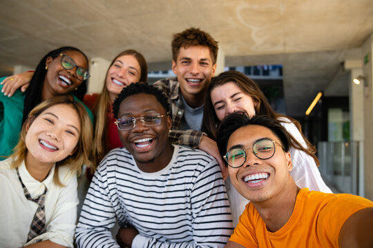A Diverse Group of Friends Enjoying Each Others Company and Smiling Together in a Modern Space