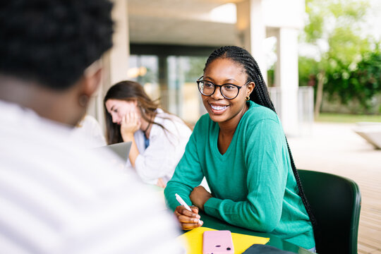 A vibrant and diverse group of young individuals is actively engaged in collaborative learning