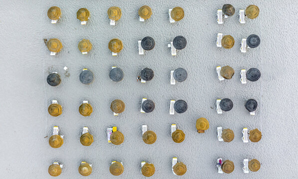 Aerial view of what appears to be a collection of bottle caps, some tarnished and aged, arranged in a grid-like pattern, Sesimbra, Setubal, Portugal.