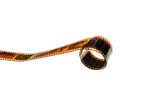 A roll of orange photographic color film curled against a white backdrop.