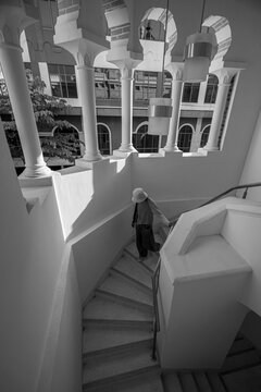 Tourist walking down a staircase inside Sultan Abdul Samad building