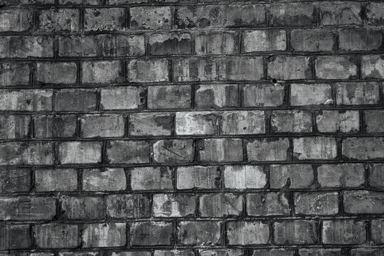 Weathered gray brick wall texture with dark mortar and rough surface details.
