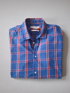 Blue and Red Plaid Button Up Shirt Hanging on Neutral Background