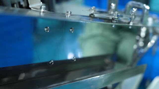 assembly line for the production of disposable syringes, syringes going down the line oe by one