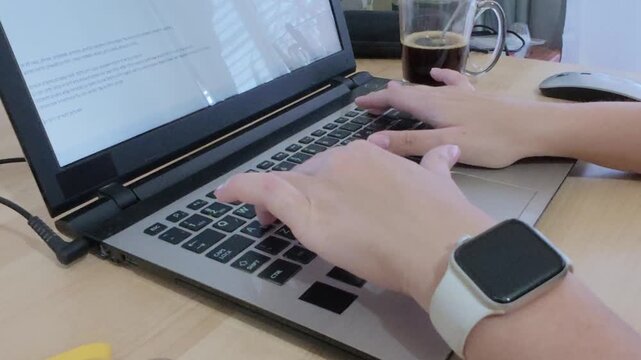Developer's hands meticulously typing code on a laptop keyboard.