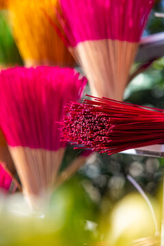 View of vibrant bundles of red, pink, and yellow incense sticks create a colorful display, their delicate tips contrasting with the sturdy bases, Hue, Vietnam.