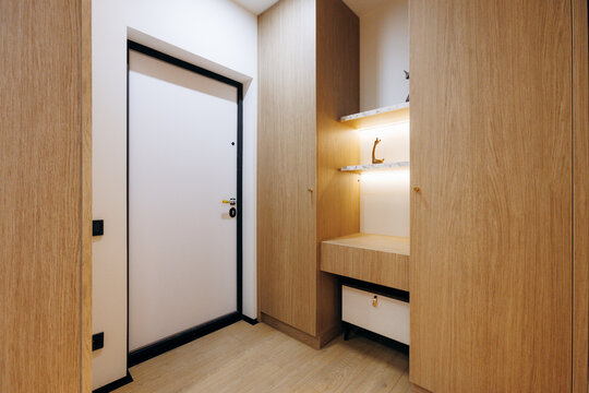 Stylish Urban Residence Showcases Cozy Wooden Entryway With Illuminated Shelf And Seating Area