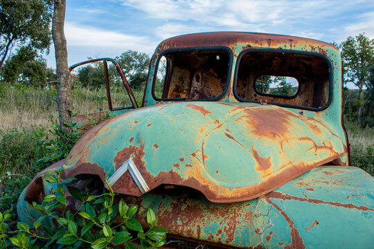 Vieille Voiture Pick up abandonn&eacute;e en pleine nature. La t&ocirc;le de cette &eacute;pave est attaqu&eacute;e par la rouille et le v&eacute;hicule est compl&egrave;tement d&eacute;glingu&eacute;.