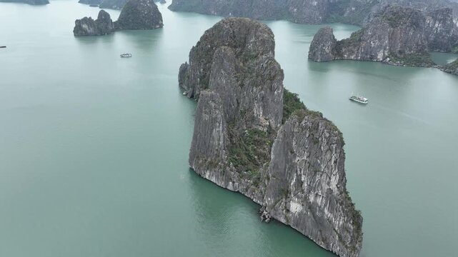 Aerial view of striking limestone karsts emerging from serene waters, showcasing the unique beauty and geological formations, Halong Bay, Vietnam.