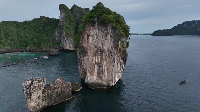 Aerial view of towering limestone karsts emerging from the turquoise waters, their faces etched with time and crowned with green foliage, Halong Bay, Vietnam.