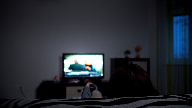 Person Watching Television Relaxing Indoors at Night, have fun and enjoy