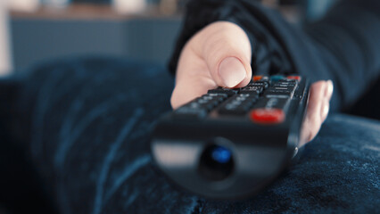 Fototapeta premium Person Holding TV Remote Control in Hand with Focus, have fun and enjoy