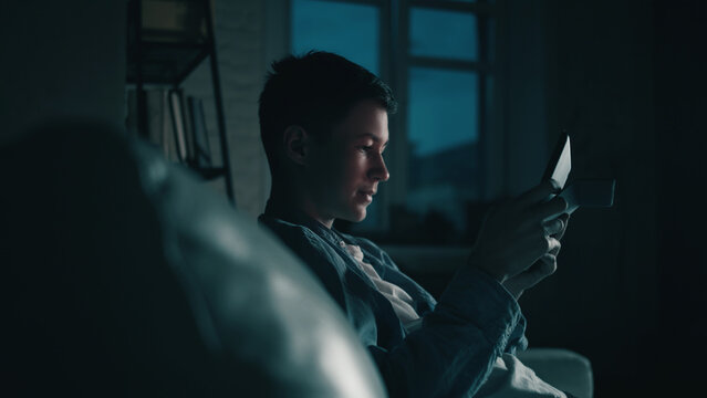 Man Reading Book Late at Night on Couch, have fun and enjoy