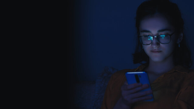 Young Woman Using Smartphone in Dark Room at Night, have fun and enjoy