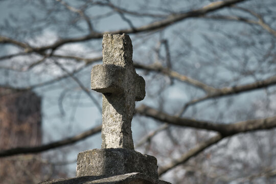 Ancient Weathered Stone Cross Standing in a Cemetery During Autumn Days