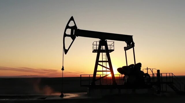 Silhouette of an oil pump jack working in a desert field at sunrise, generative AI