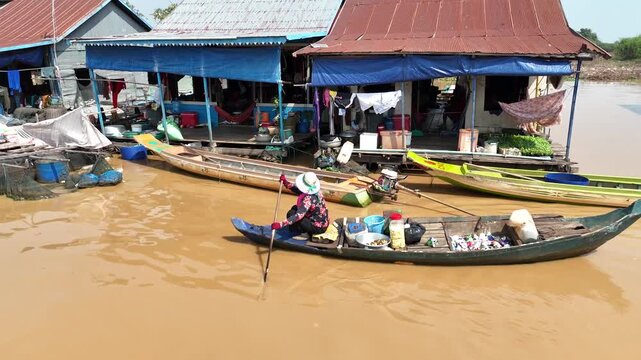 Aerial view of boats navigating through waters surrounded by stilt houses creating a contrast of colors and textures, Chong Kneas, Cambodia.