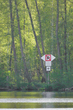 No Parking Traffic Sign and Forest Fire Warning Located at a River Bank