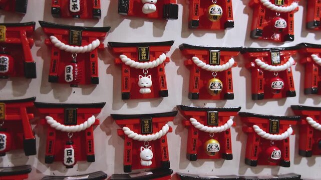 Traditional Japanese tourist souvenirs and gifts from Kyoto, Kansai, Japan, with daruma figures, kitsune fox, tengu mask, fridge magnets, toys figurines, key ring keychain, in a local vendor gift shop