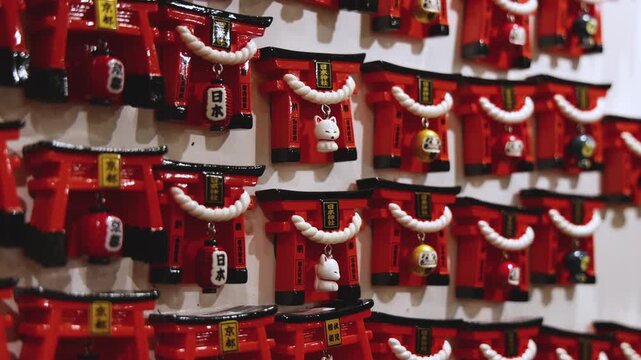 Traditional Japanese tourist souvenirs and gifts from Kyoto, Kansai, Japan, with daruma figures, kitsune fox, tengu mask, fridge magnets, toys figurines, key ring keychain, in a local vendor gift shop